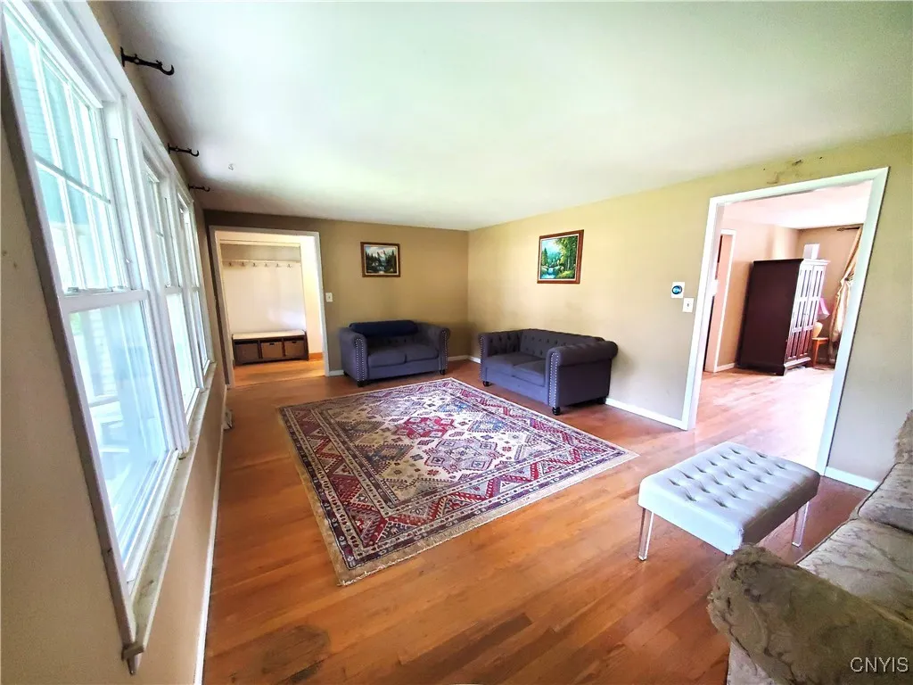 Large, bright livingroom. Foyer (background), diningroom (right)