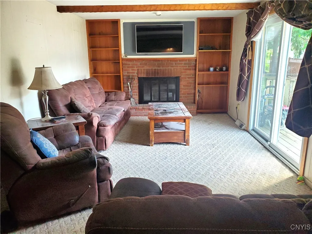 View to wood burning fireplace with shelving each side.
