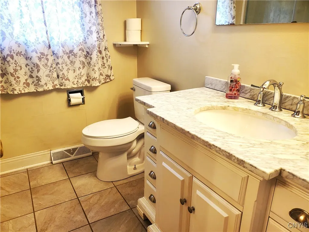 Second floor hall bathroom with tile flooring.