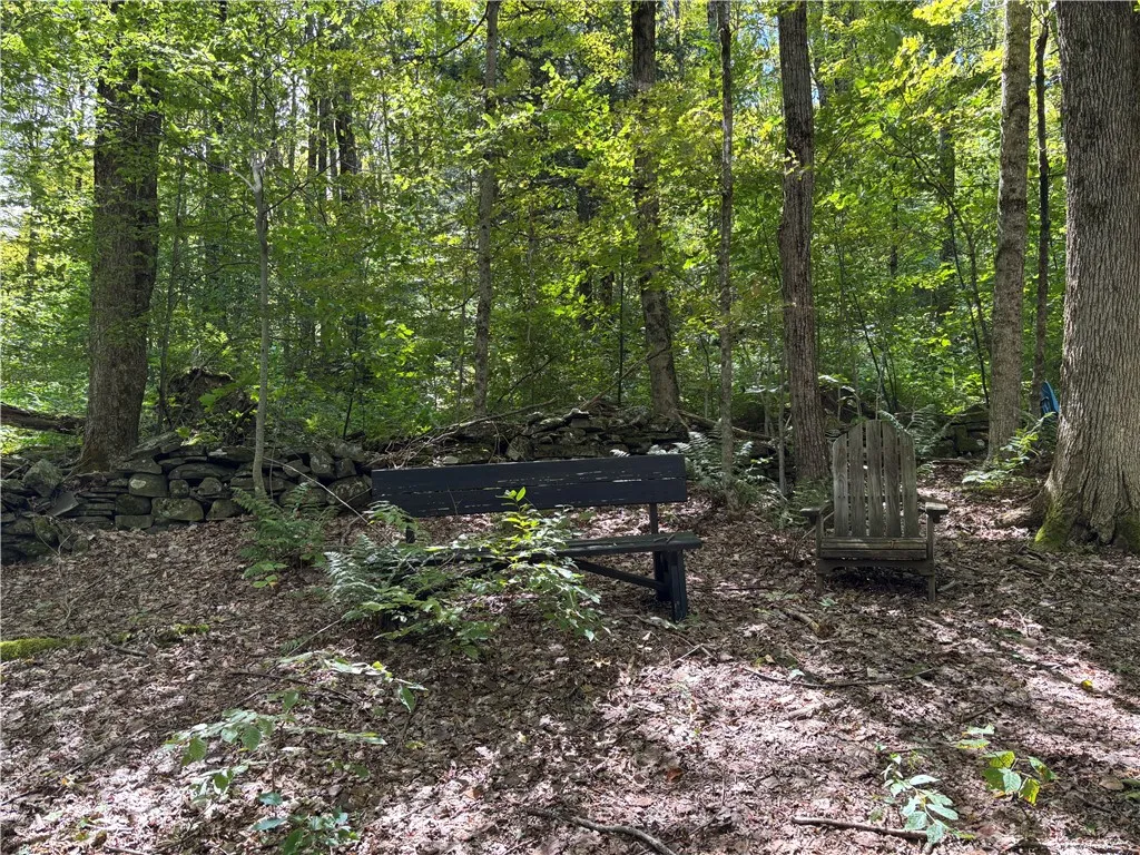 Rock wall is the boundary line indicator for the sides and back of the property.