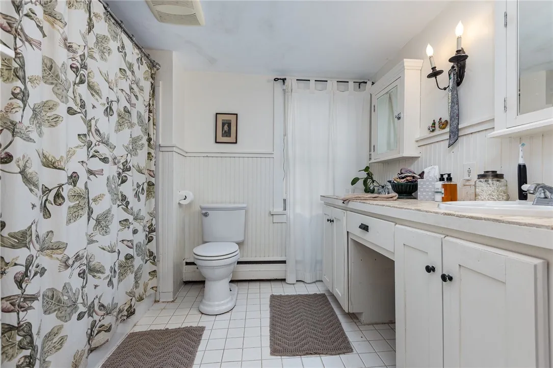 Full bath upstairs with a double sink vanity and tile floors.
