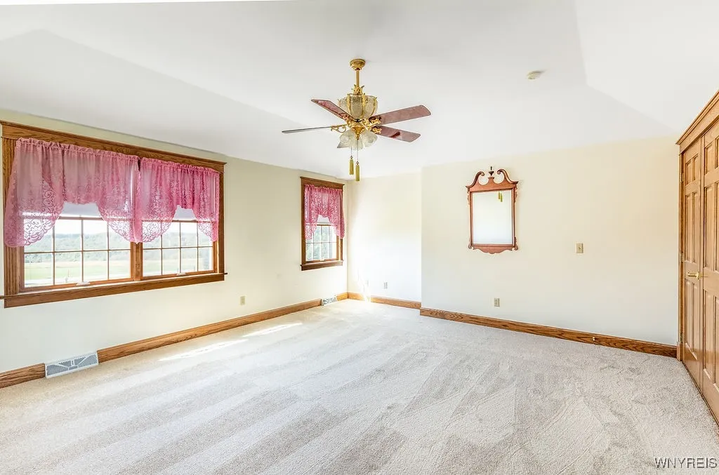 Large bright primary bedroom with tray ceiling