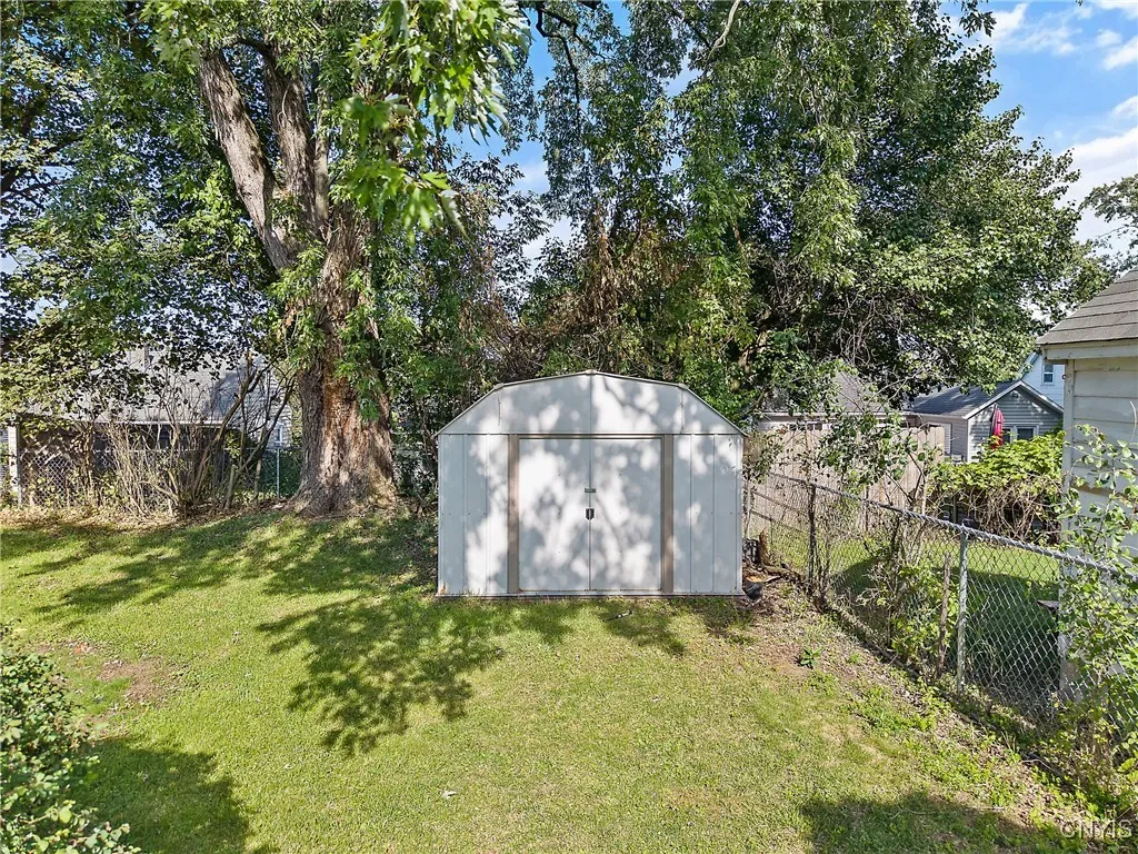 Turning towards the back of the yard, here we see a metal shed, perfect for storing your landscaping and outdoor tools.