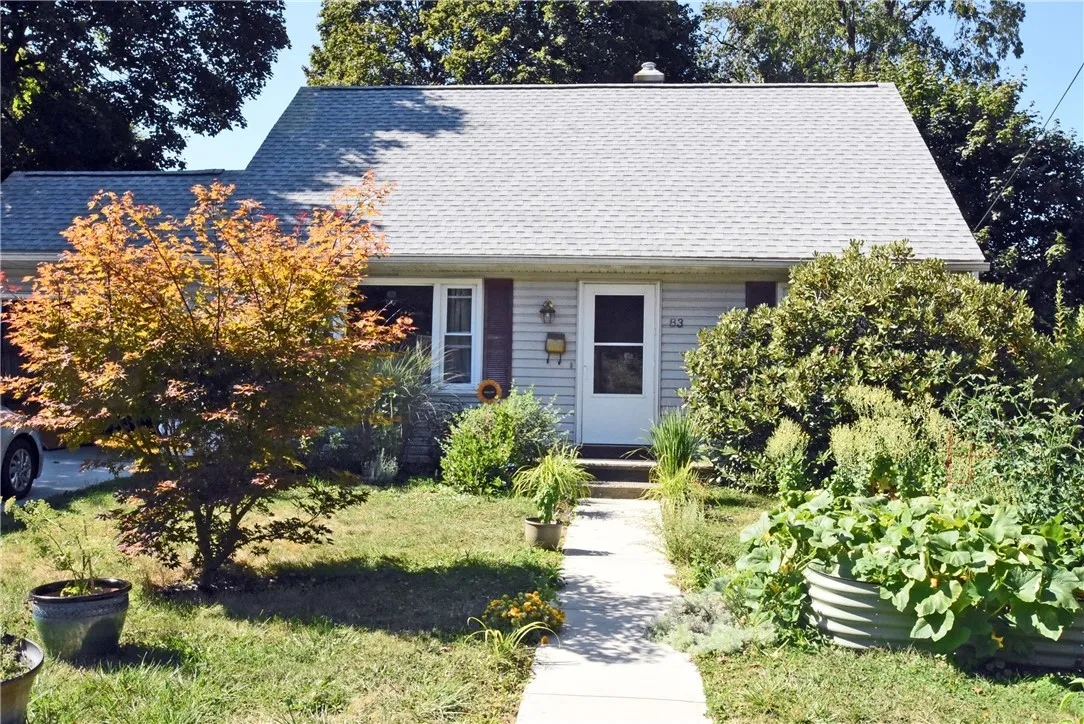 Front of home with raised vegetable gardens.