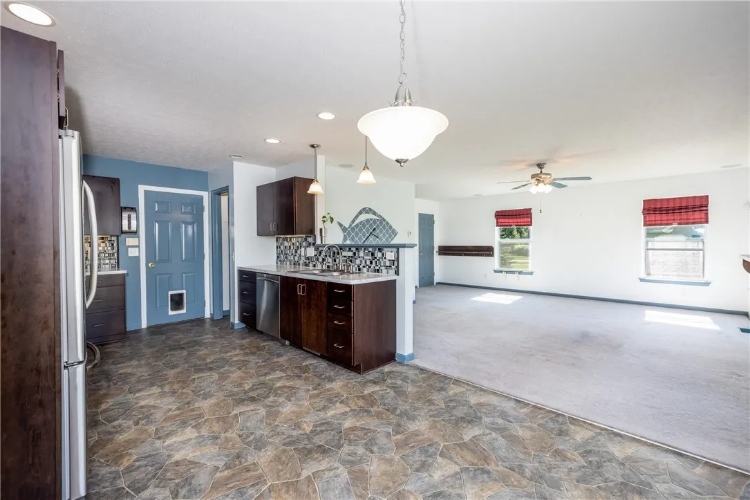 BEAUTIFUL EAT IN KITCHEN WITH CUSTOM CABINETRY, STAINLESS STEEL APPLIANCES WITH BACKYARD VIEWS VIA SLIDING GLASS DOOR.