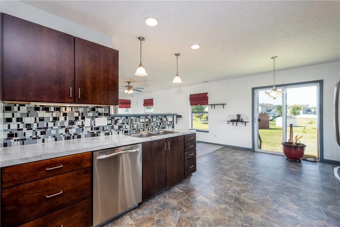 BEAUTIFUL EAT IN KITCHEN WITH CUSTOM CABINETRY, STAINLESS STEEL APPLIANCES WITH BACKYARD VIEWS VIA SLIDING GLASS DOOR.