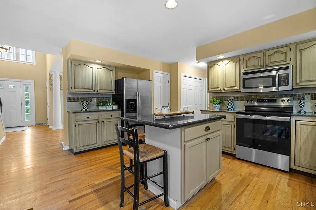 Stainless steel appliances with electric stove & center island that can easily seat 4