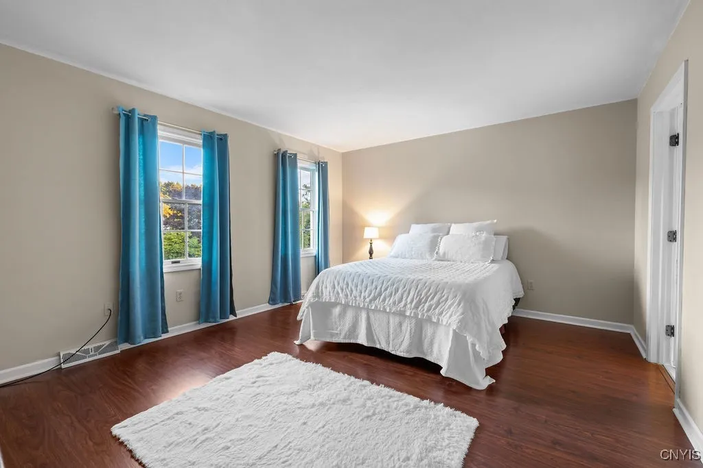 Primary bedroom with laminey floors & windows that will bring in nice light