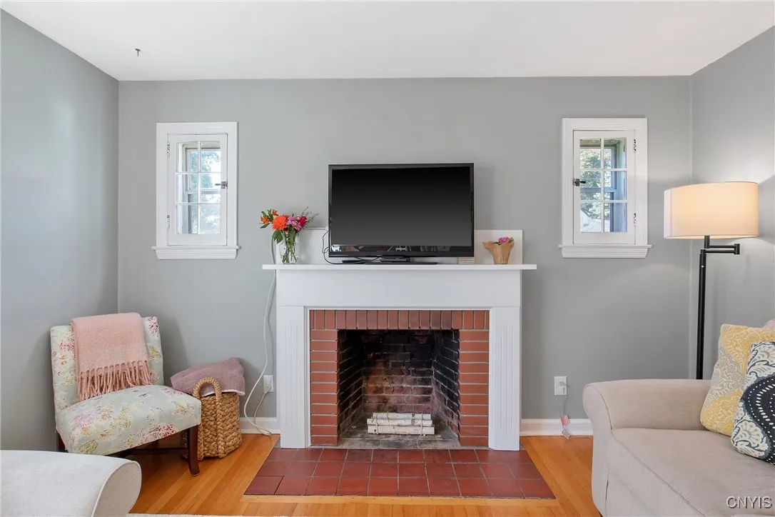 Wood burning fireplace flanked by windows