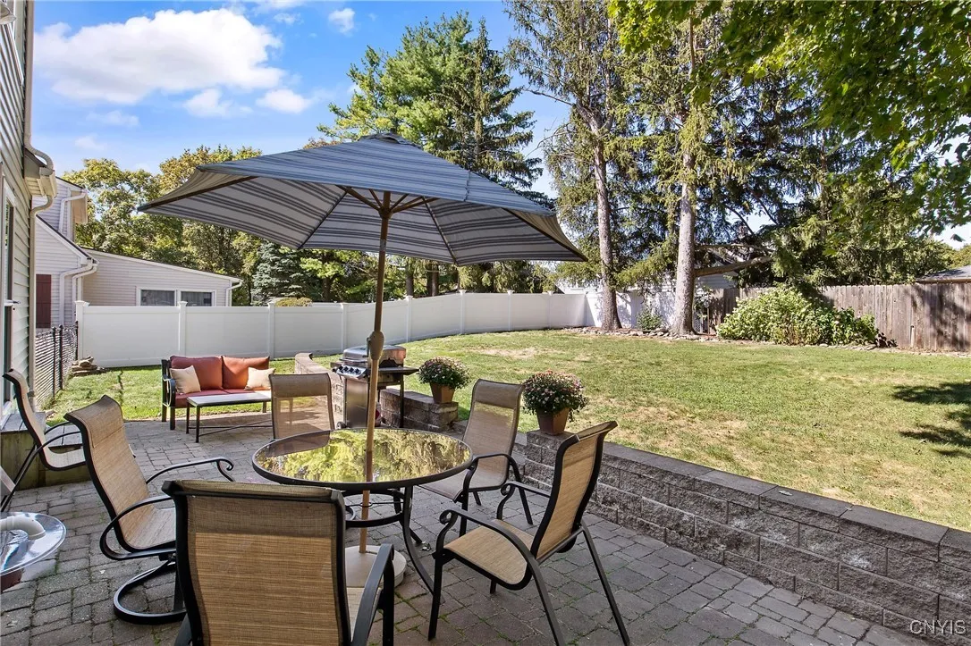 Beautiful paver patio with accent stone wall with level grass area behind