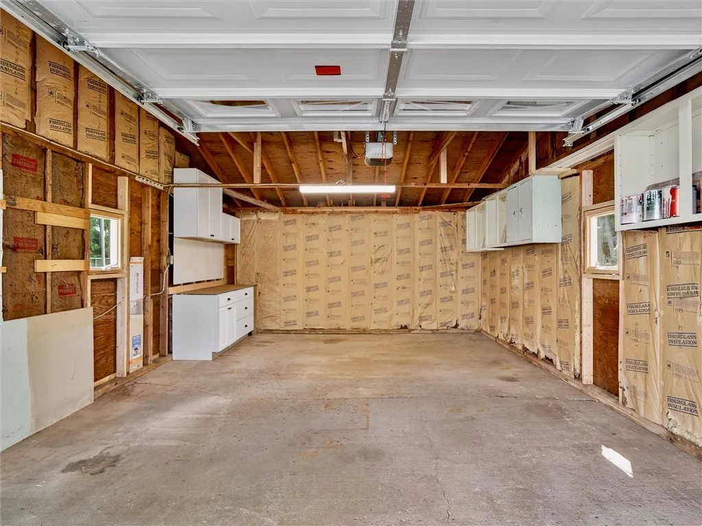 1.5 car garage with new siding, new overhead door and opener, new cabinets for work area, new windows and man door, new lighting