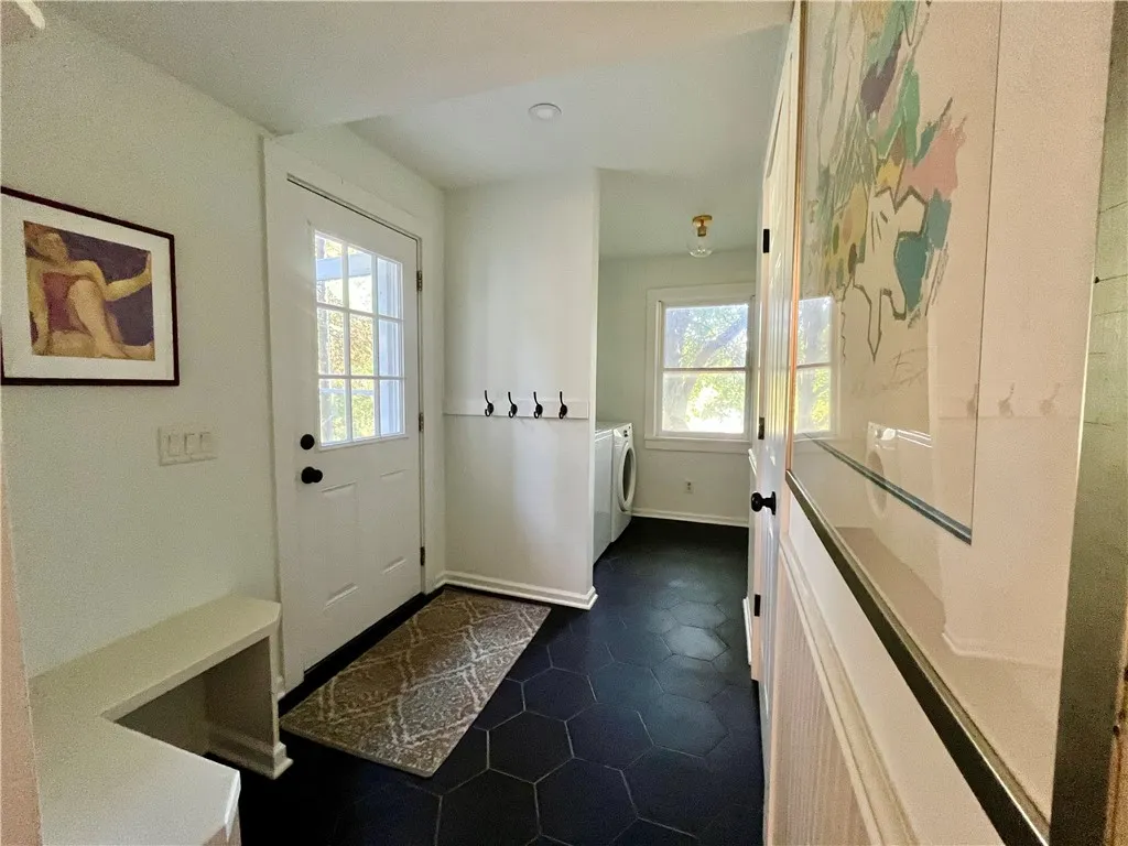 A mud room off the side entrance with a powder room and laundry