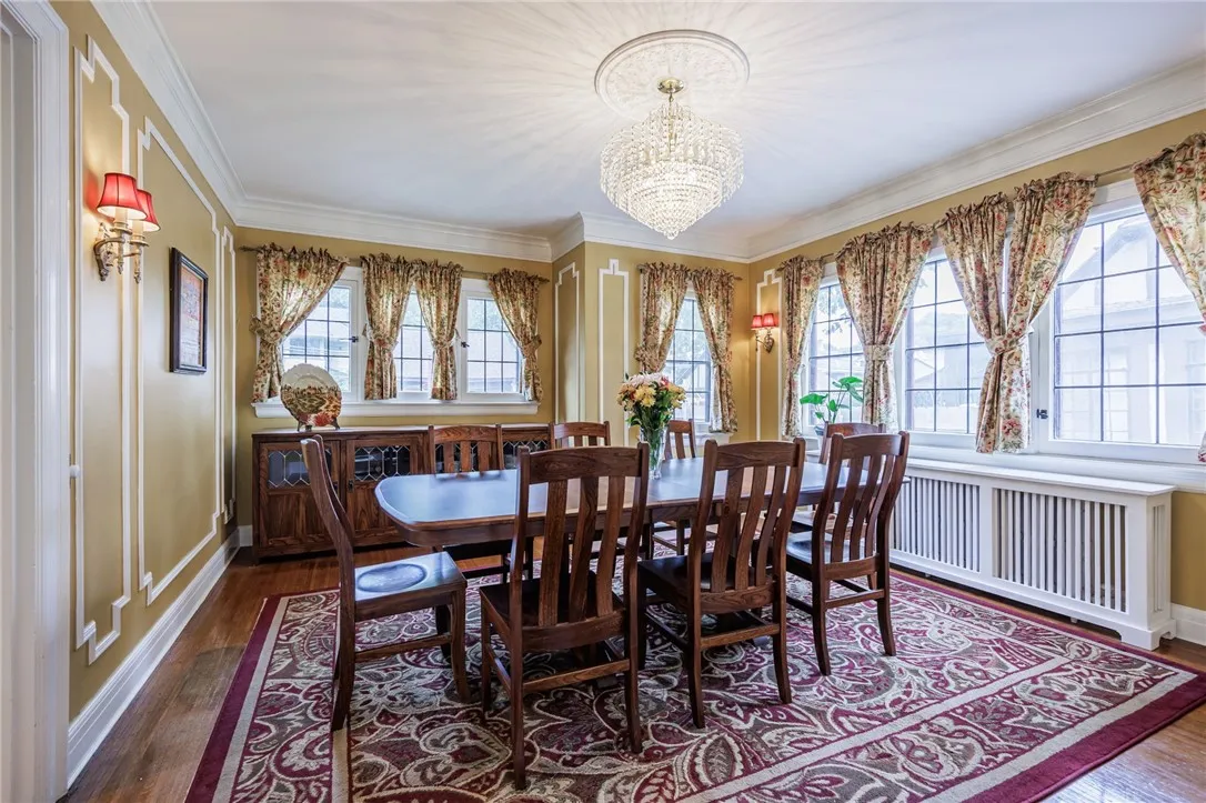 Formal diningroom with warm, inviting glow from the wall sconces and crystal chandelier