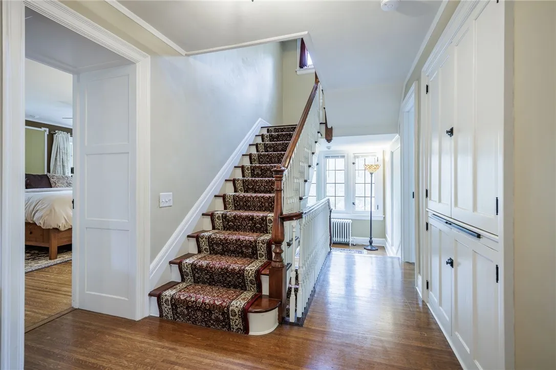  2nd floor hallway with roomy built-ins and staircase that winds to 3rd floor