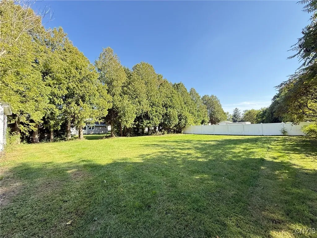 The expansive yard offers endless possibilities—beyond the hedgerow