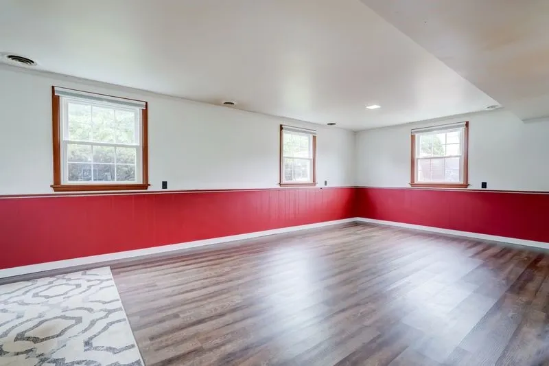 View of the family room level from the powder room with new flooring and multiple windows on 3 sides.