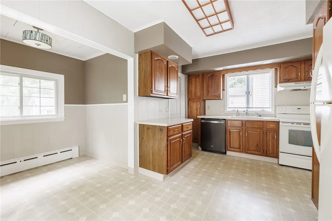 Spacious Eat-In Kitchen with wood cabinetry & neutral Formica countertops