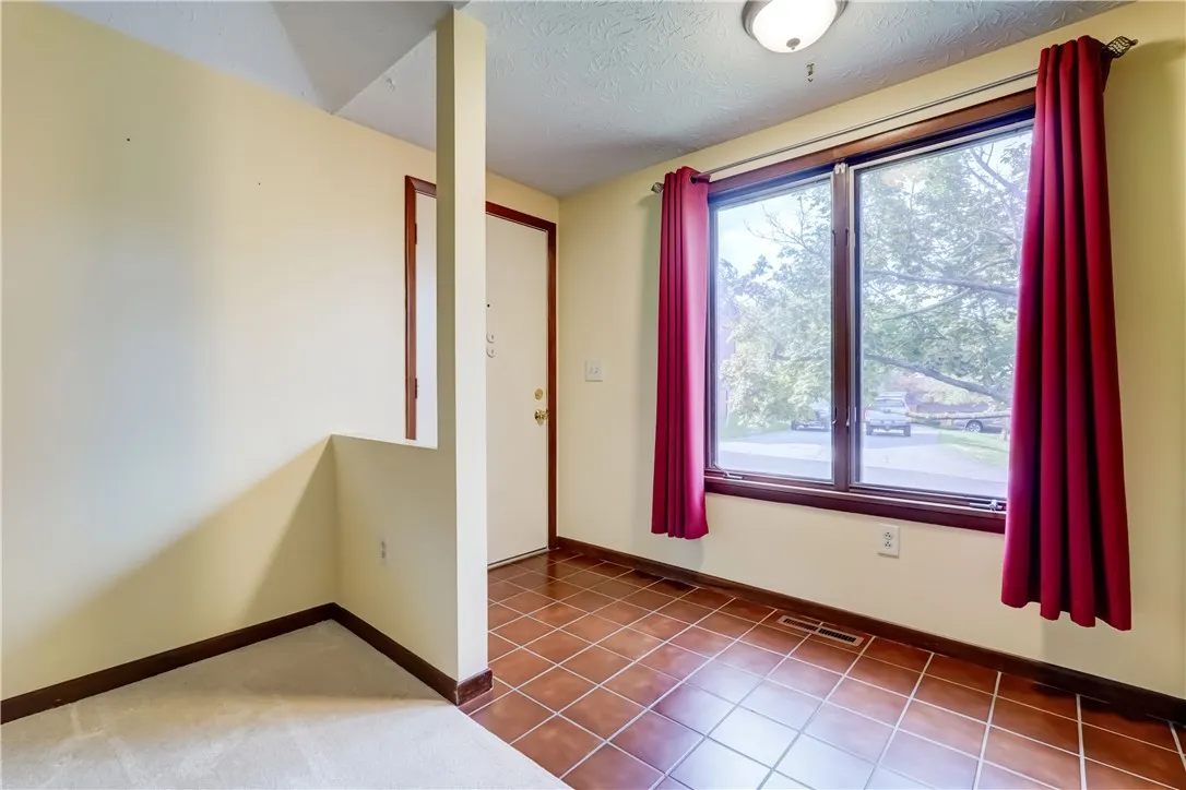 Entry hall has easy-to-clean tile floors and double windows overlooking the front yard.