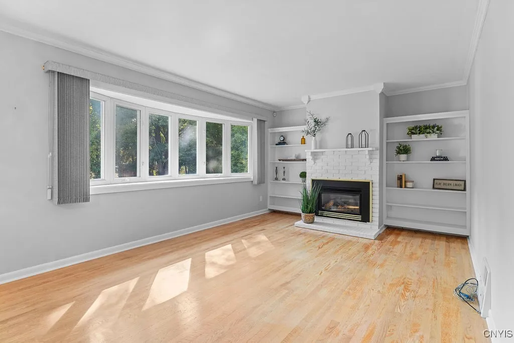 Living room with gas fireplace with built in book shelves on either side.