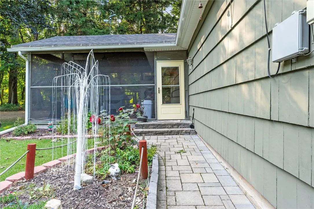 Walk way along side of garage leading to door to screened in porch