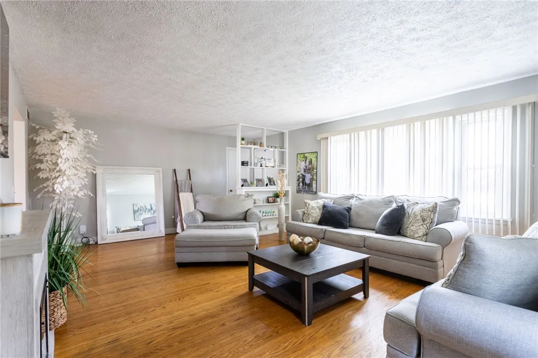 Huge Living room with large window that brings in nice light and boasting gorgeous hard wood flooring.