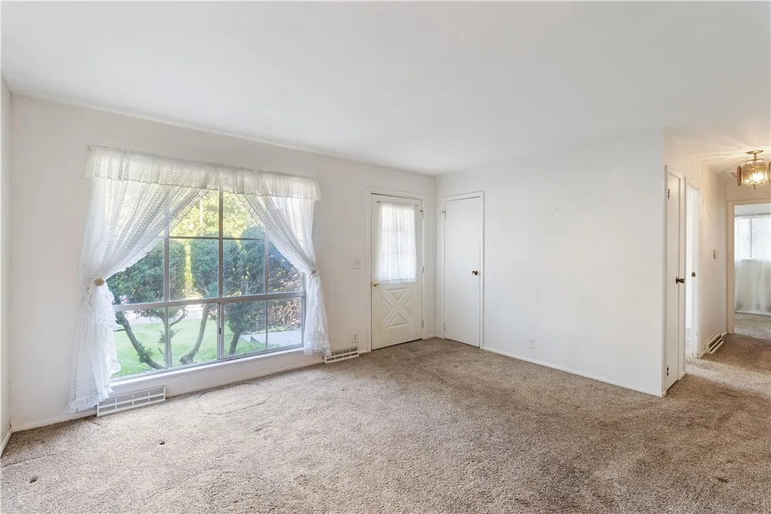 Cozy living room w/floor to ceiling front window for natural light.