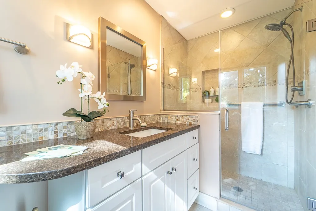 The ensuite primary bath is updated with granite counters, and tiled shower with built-in bench