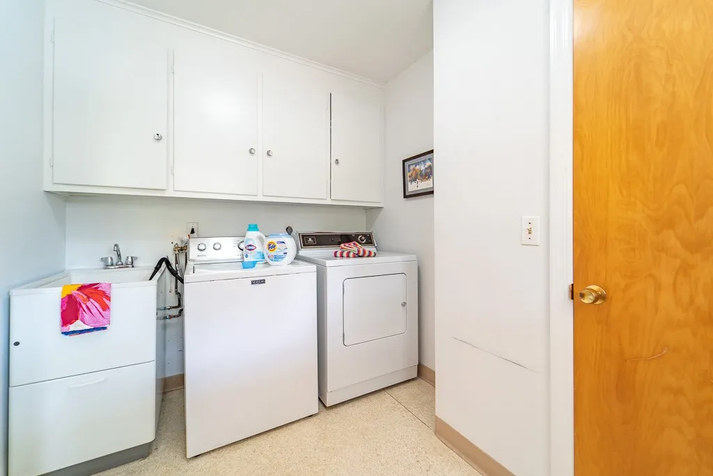 The spacious first floor laundry includes washer/dryer, utility sink, storage cabinets and closet.