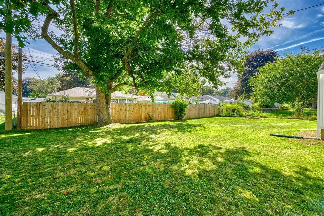 Semi-private backyard framed by mature trees and fencing.