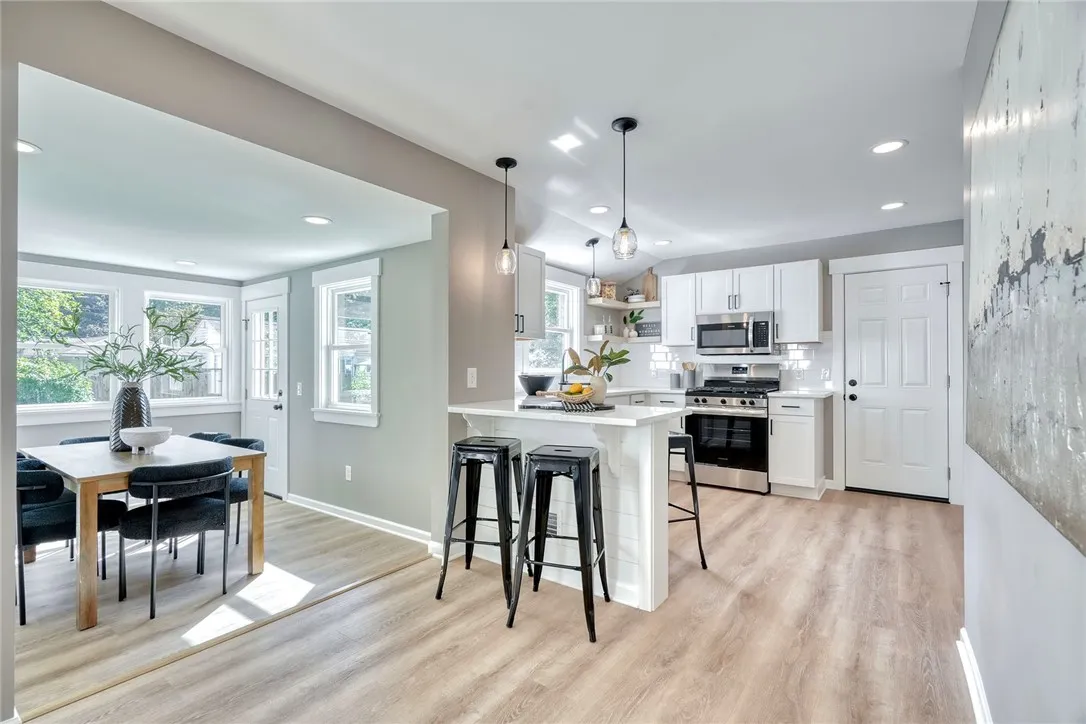 Bright, modern kitchen with quartz countertops, stainless appliances, and open shelving.