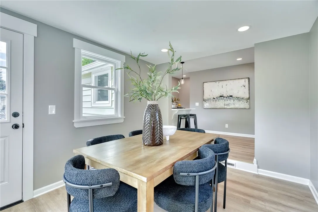 Sun-drenched morning room with oversized windows, perfect for dining or relaxing.
