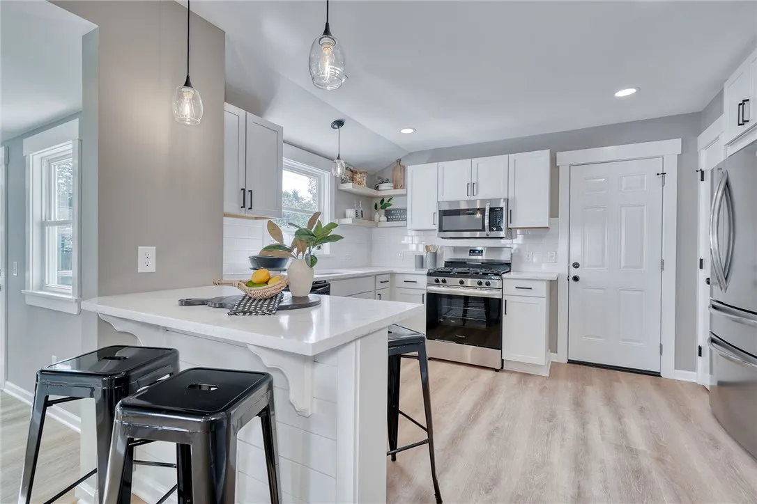 Breakfast bar seating and open flow to the living and dining spaces