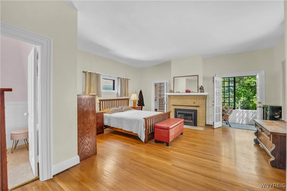Primary Suite with full bath, enclosed balcony, and fireplace
