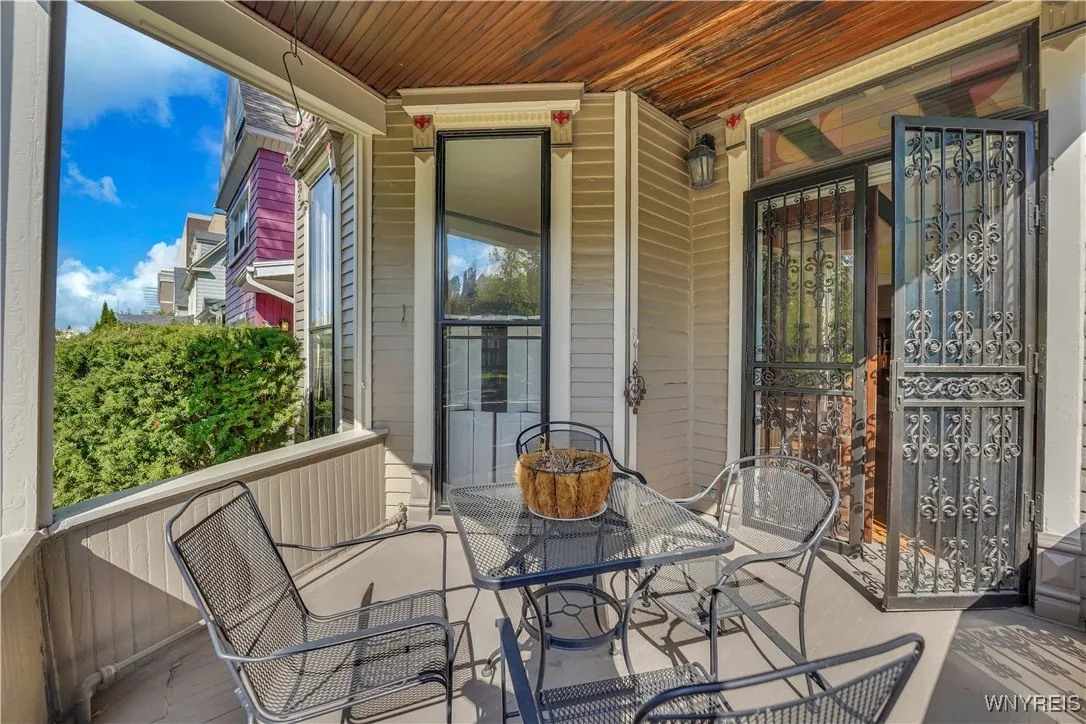 The covered front porch on the right side of the home is accessed via the living room French doors.
