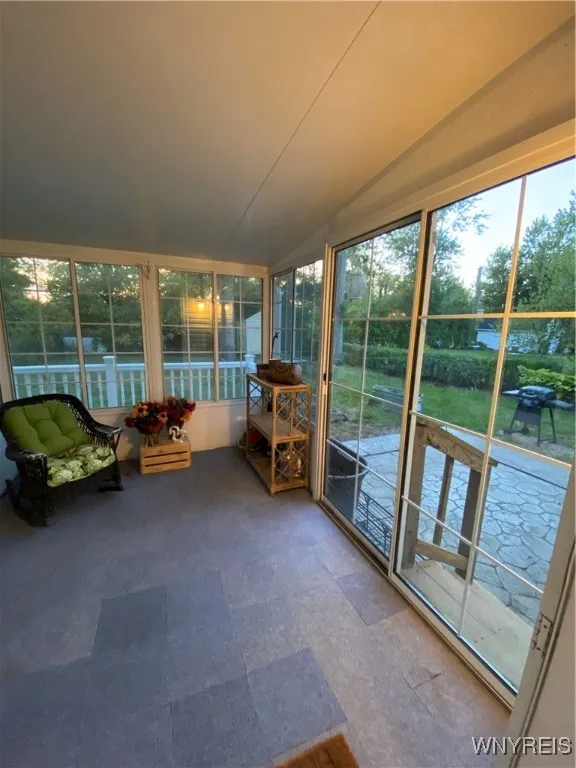 Sunroom showing sliding glass door to stone patio
