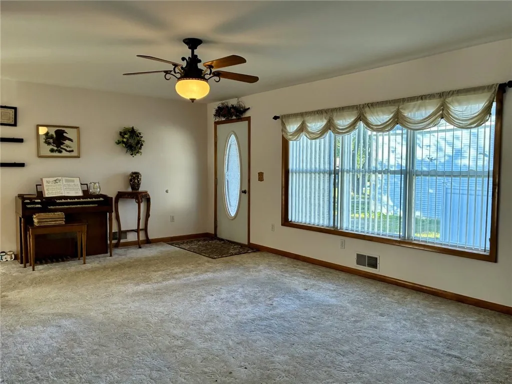 The dining room has tasteful sculpted carpeting, a wall of windows, custom linen roman shade valances and as you can see, lots of room for visitors. The custom blinds are throughout the home.