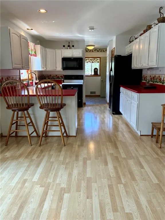 This kitchen is ample size! Lots of cupboards, expansive amounts of counterspace and it has a breakfast bar!