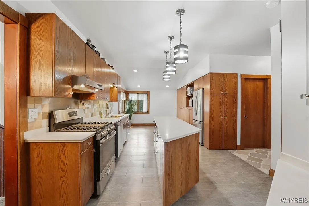 Update kitchen that has been extended to provide a large eating area surrounded by windows. Built in frig and full wall of storage. Corian counter tops and 2 sets of pull out drawers in the island for a total of 6.