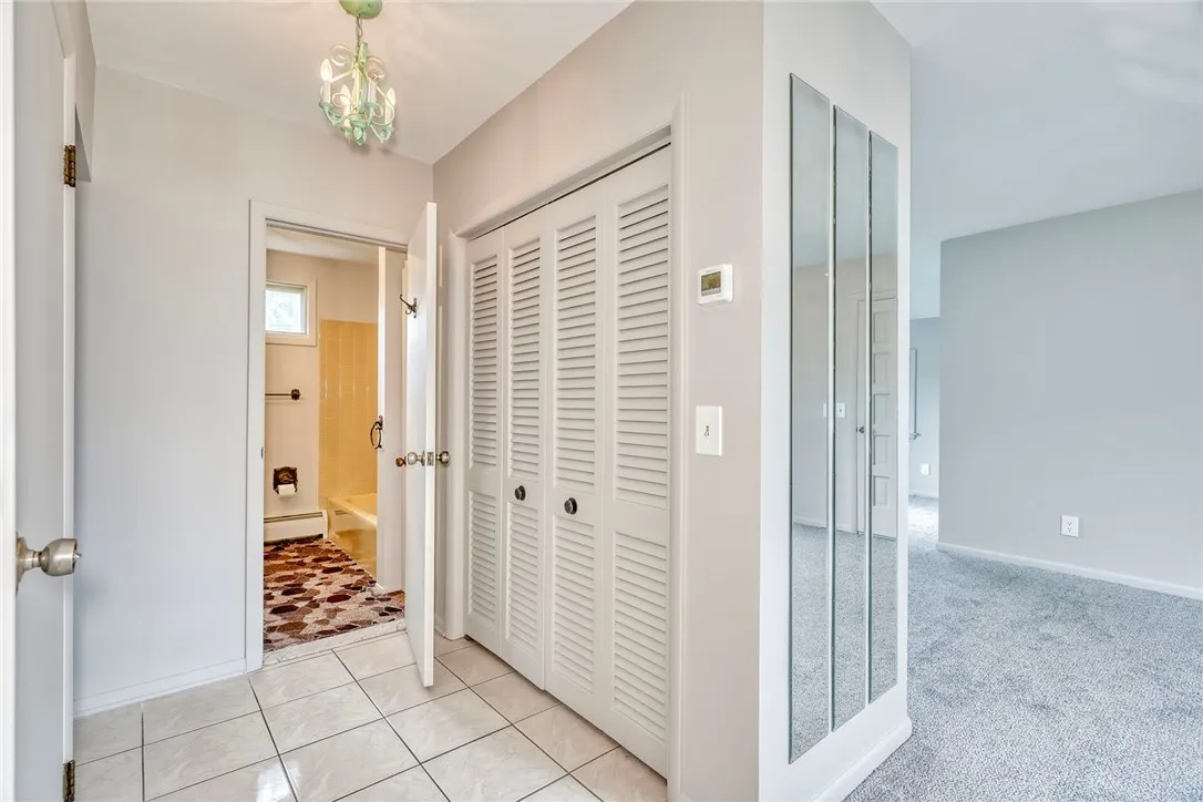 Hallway is ceramic tile with convenient double closet for coats and guest coats. View into full bath. Door to left leads to basement.