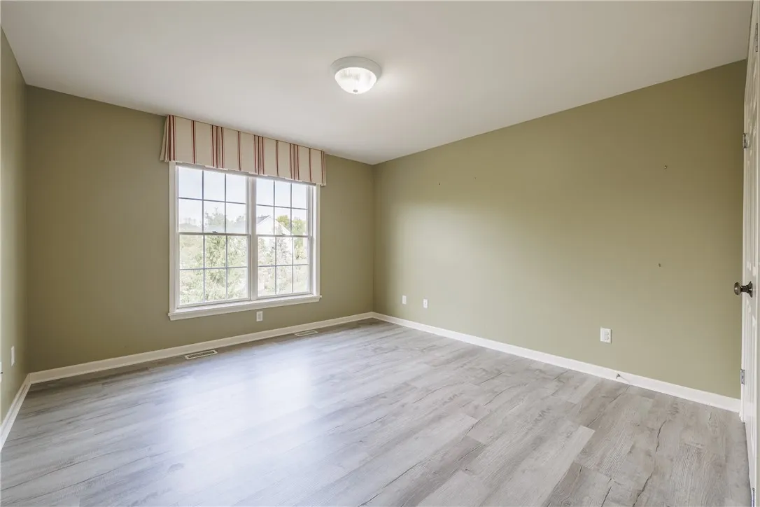 Bedroom 4 with luxury vinyl flooring and a custom window topper.