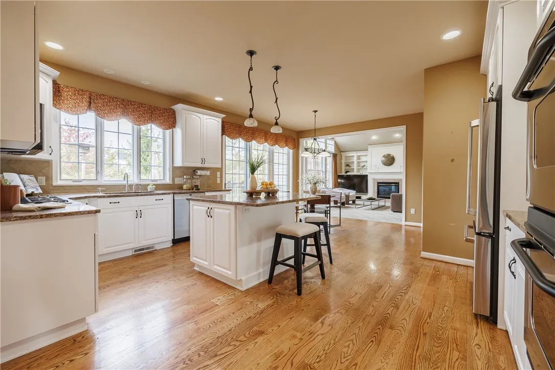 Windows galore show off the gleaming hardwoods in this bright, white kitchen