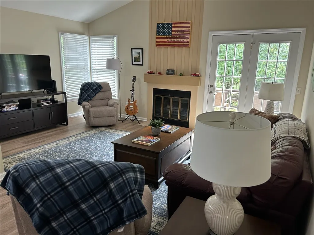 Living room with vaulted ceiling and  wood fireplacefirelplace
