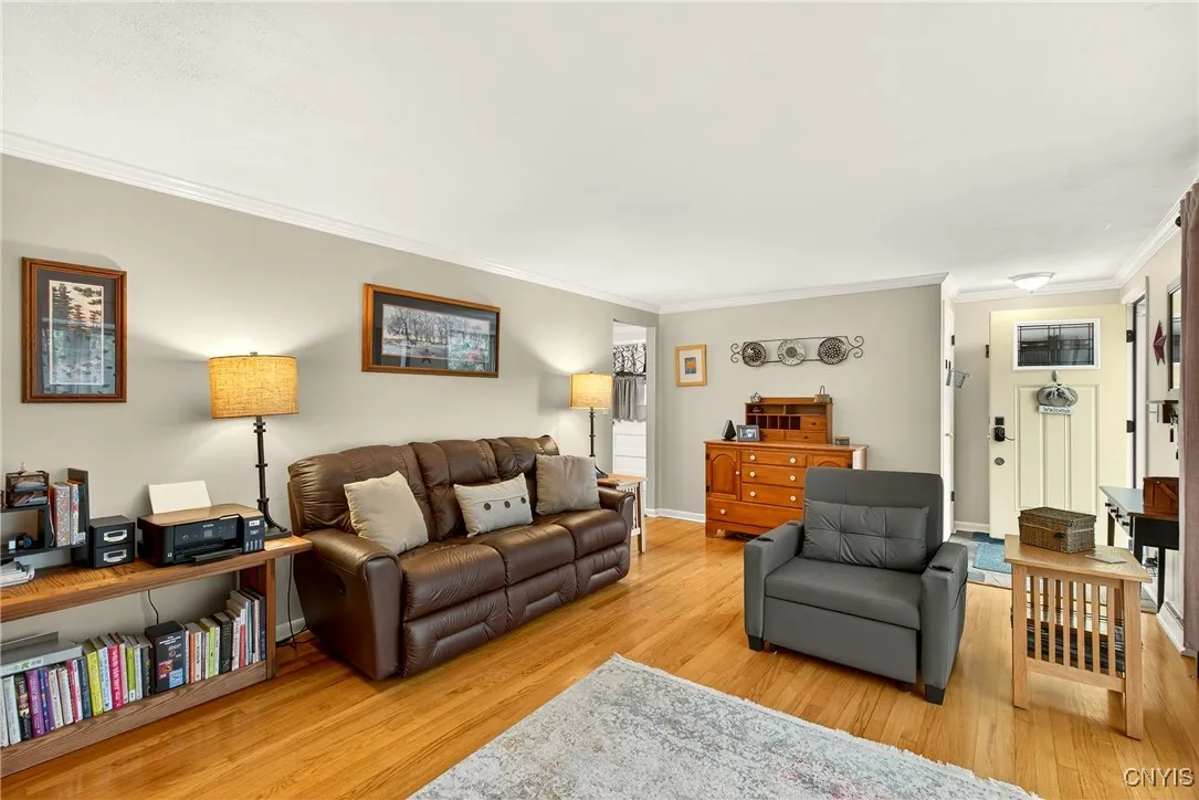 And now we enter the long, wide living room with sparkling hardwood floors and crown molding at the ceiling that adds a touch of elegance.