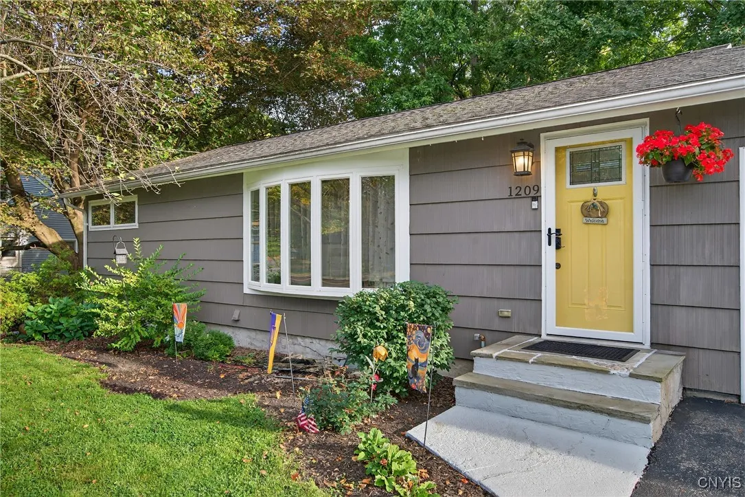 The pretty bay window is a charming accent as you approach the cheery front door up the steps here at the main entry.