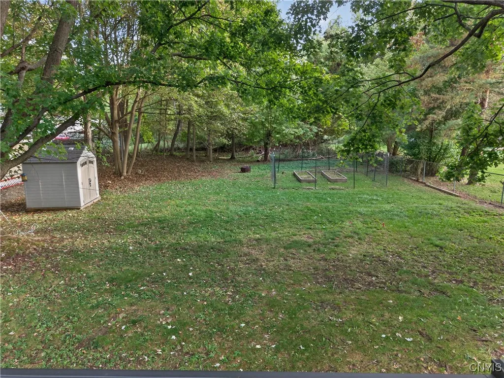 And note the cute, fenced garden bed area where you can try your hand at growing veggies or herbs plus the shed at left here can house your yard equipment so the garage can stay open for your vehicle.