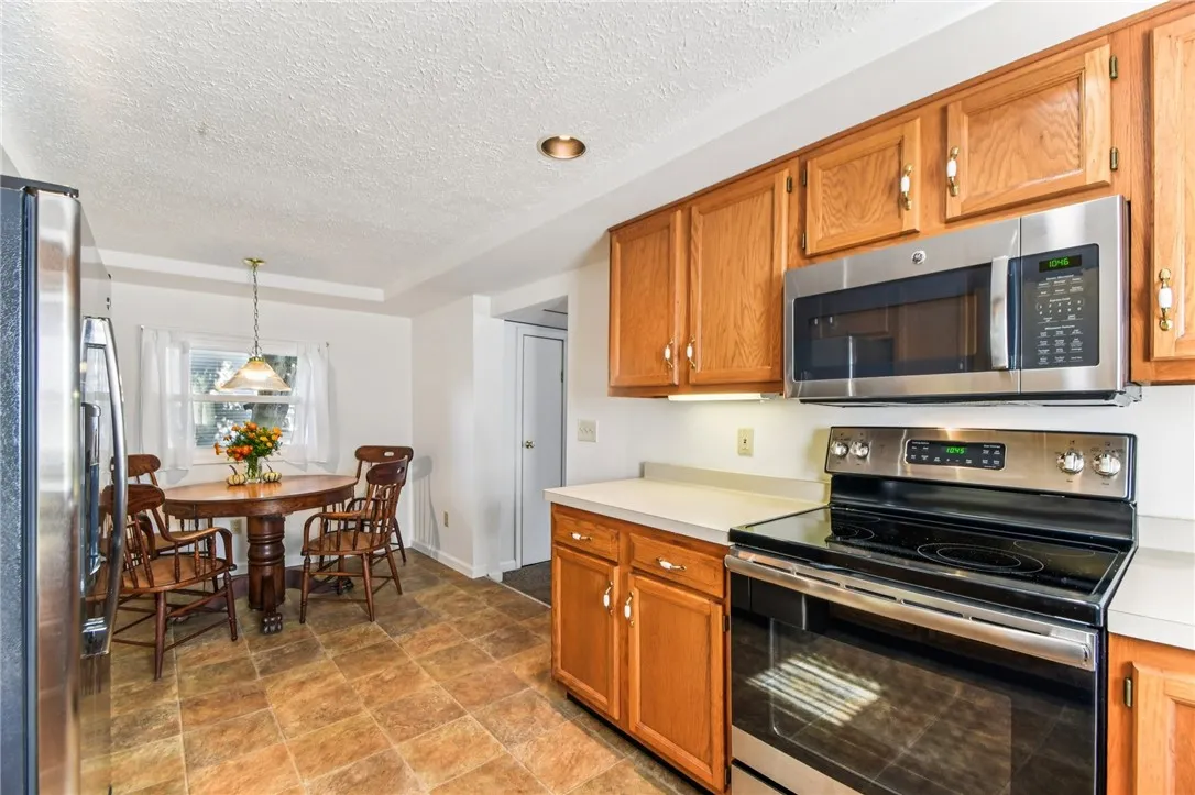 THE EAT-IN KITCHEN ALSO HAS BRAND NEW STAINLESS-STEEL REFRIGERATOR, ELECTRIC RANGE AND MICROWAVE. THERE IS RECESSED LIGHTING AND VINYL FLOORING.
