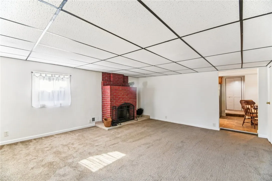 THE LIVING ROOM HAS WALL-TO-WALL CARPETING, A WOODBURNING FIREPLACE AND OPENS TO THE KITCHEN.












