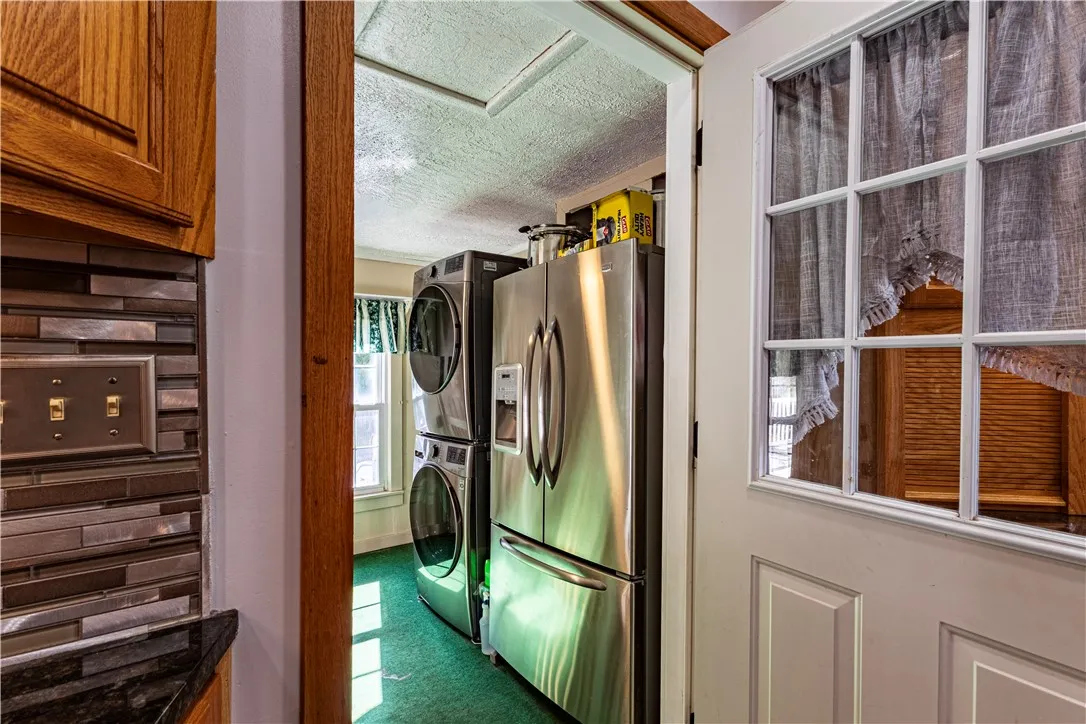back room with laundry and extra refrigerator