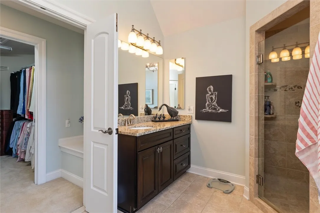 One of two vanities in the spa-like primary bath — featuring rich cabinetry, granite counters, and a thoughtful layout that offers both elegance and everyday functionality.