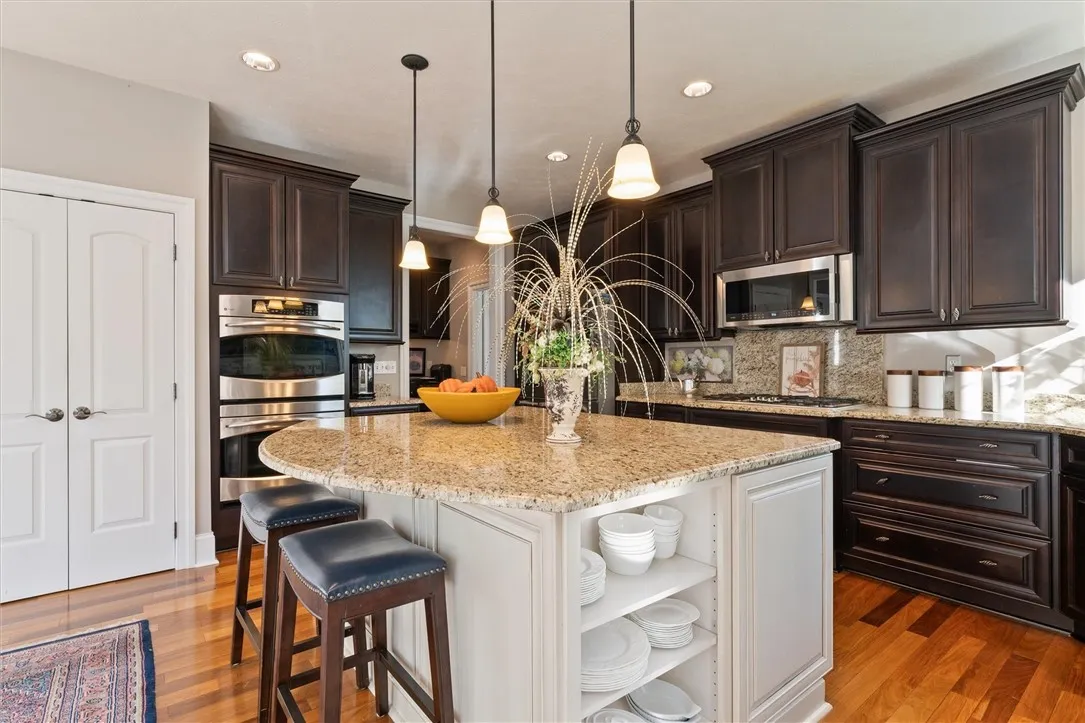 This expansive chef’s kitchen is designed for both cooking and entertaining — featuring rich wood cabinetry, granite countertops, stainless steel appliances, and a spacious island that invites everyone to gather. Thoughtful design meets timeless craftsmanship in this heart-of-the-home.”